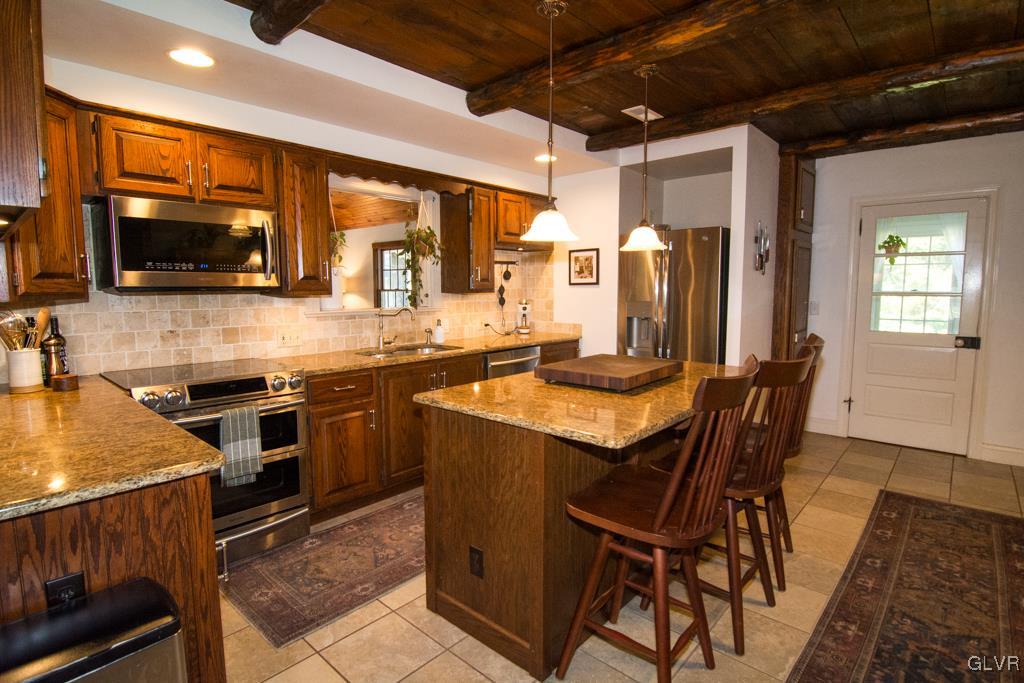 1470 Benner School Road Quakertown, PA 18951 - Photo 7 of 47 a kitchen with stainless steel appliances granite countertop a stove top oven a sink a dining table and chairs