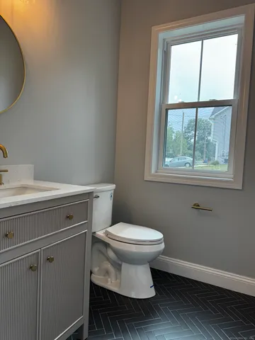 a bathroom with a toilet a sink and mirror
