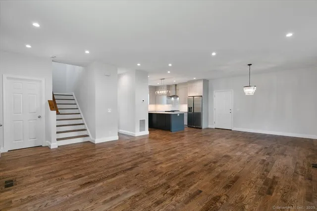 a kitchen with kitchen island granite countertop a sink and refrigerator