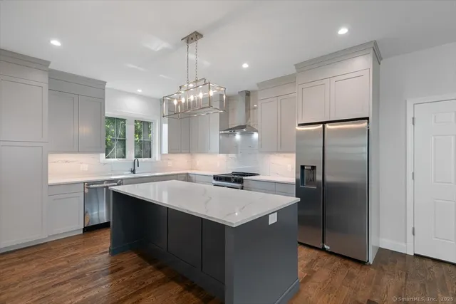 a kitchen with kitchen island granite countertop stainless steel appliances cabinets a sink and a counter top space