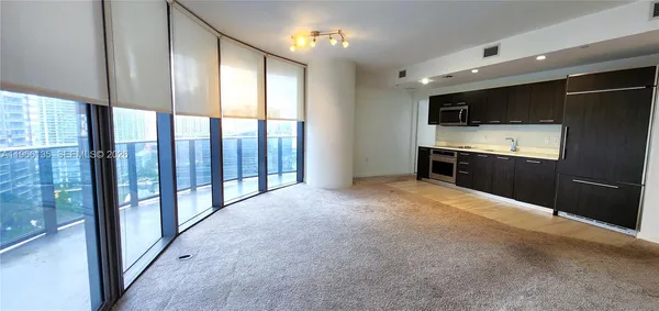 a view of kitchen with granite countertop and white cabinets