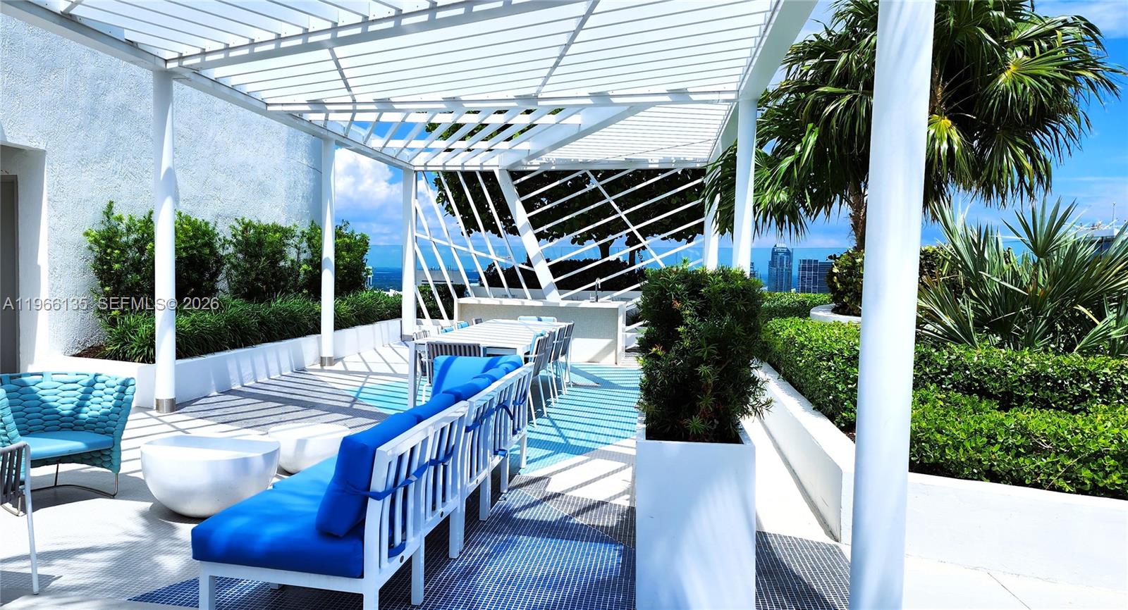 45 Southwest 9th Street, Unit 2108 Miami, FL 33130 - Photo 51 of 55 a view of a patio with table and chairs potted plants with wooden floor and fence