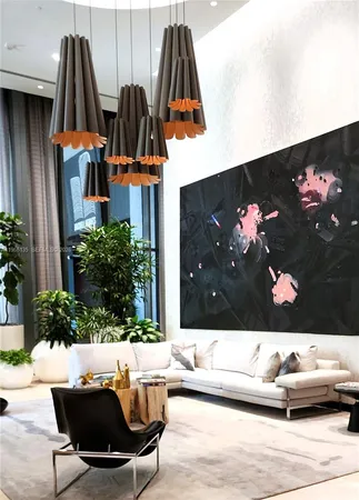 a living room with furniture a large window and a chandelier