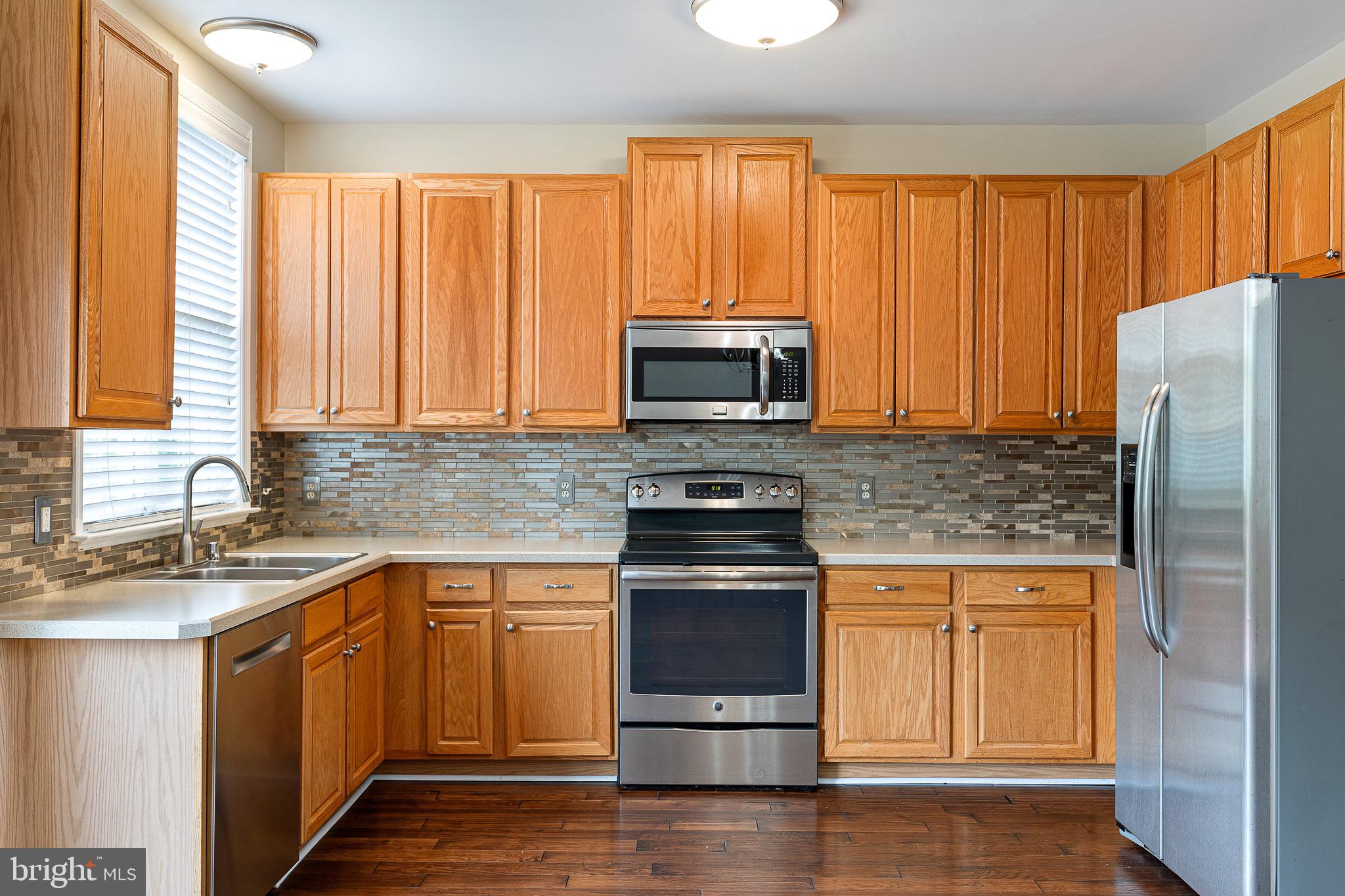 32 Ballina Boulevard Bear, DE 19701 - Photo 11 of 25 a kitchen with stainless steel appliances granite countertop a stove a sink and a microwave