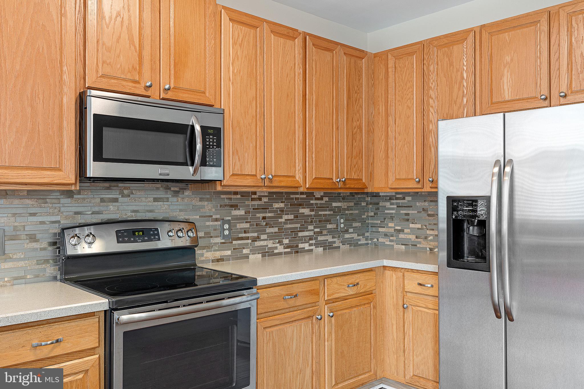 32 Ballina Boulevard Bear, DE 19701 - Photo 12 of 25 a kitchen with granite countertop a refrigerator stove and microwave