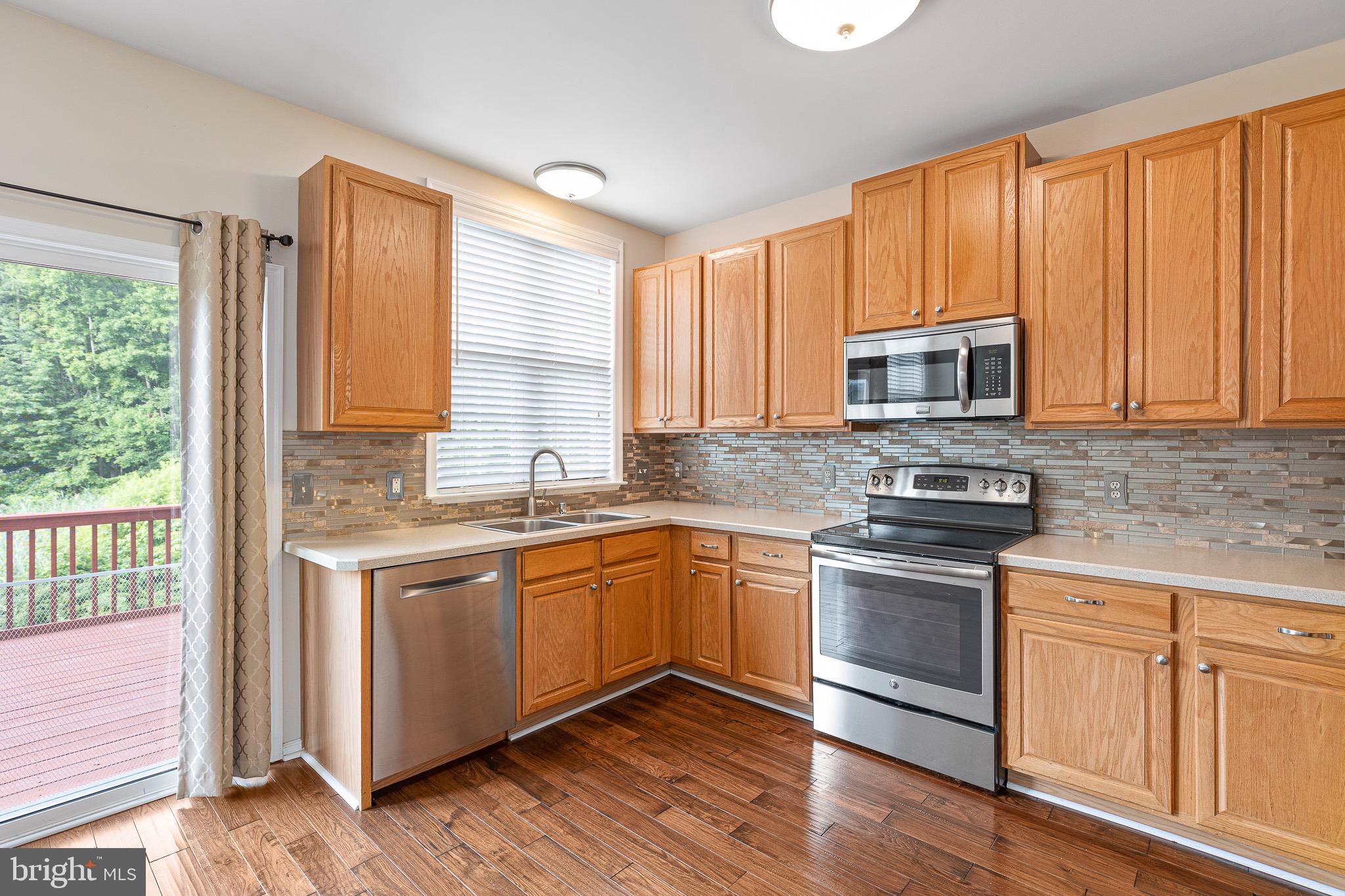 32 Ballina Boulevard Bear, DE 19701 - Photo 10 of 25 a kitchen with stainless steel appliances granite countertop a stove a sink and a microwave