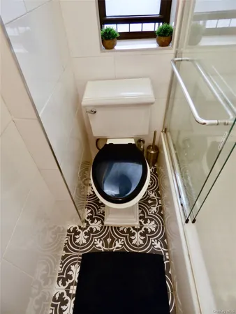 a bathroom with a toilet and a mirror