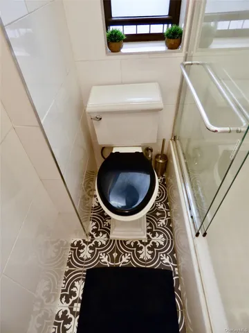 a bathroom with a toilet and a mirror