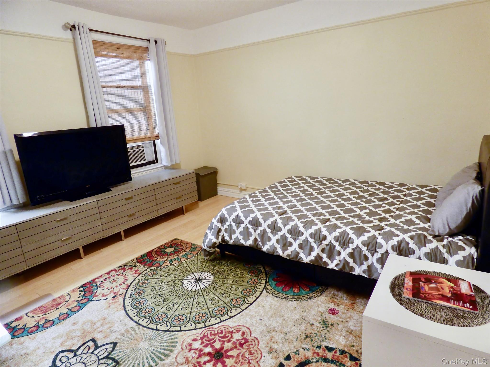 941 Jerome Avenue, Unit D5 Bronx, NY 10452 - Photo 2 of 35 a bedroom with a bed and flat screen tv