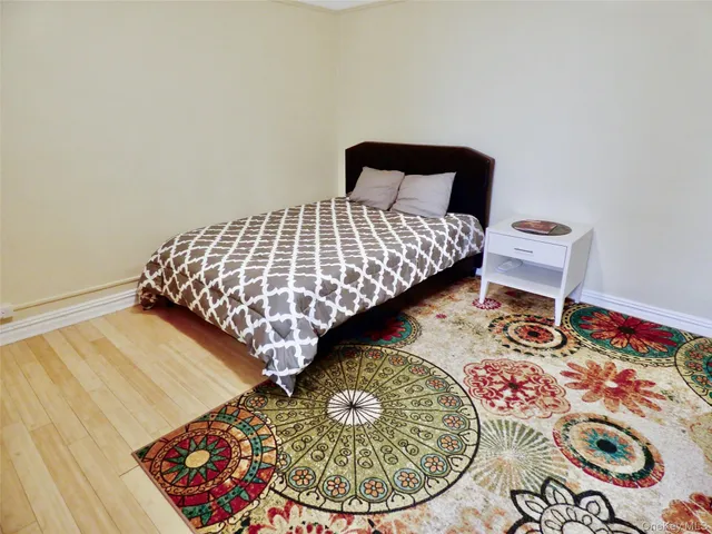 a bedroom with a bed and a wooden floor