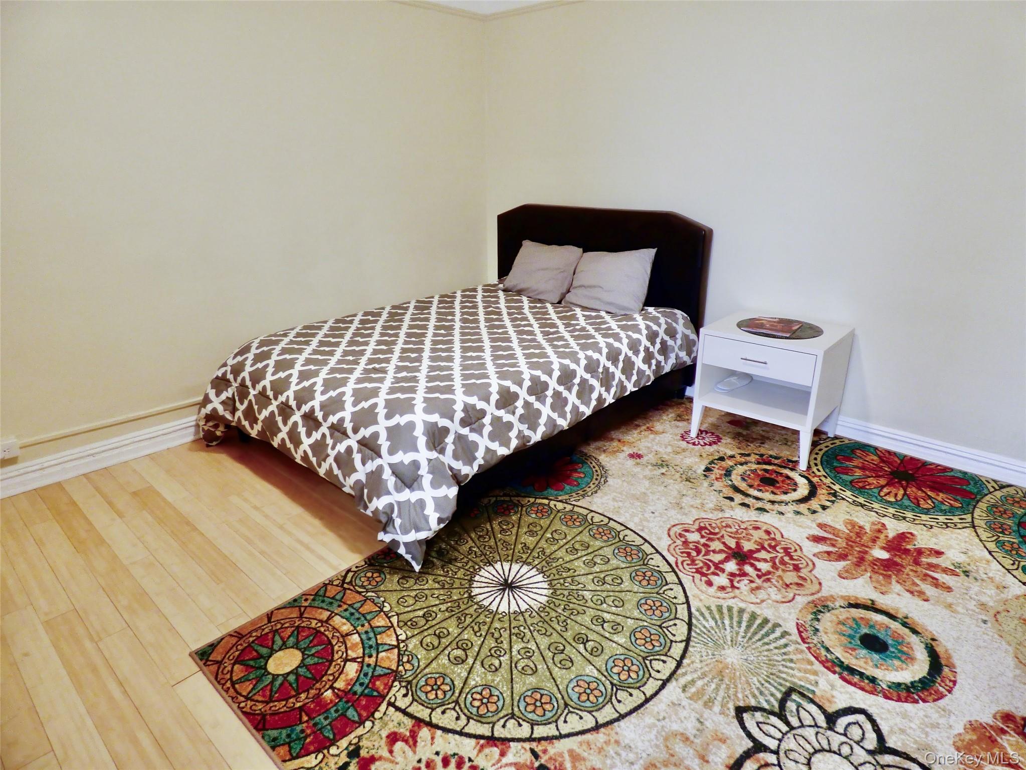 941 Jerome Avenue, Unit D5 Bronx, NY 10452 - Photo 3 of 35 a bedroom with a bed and a wooden floor