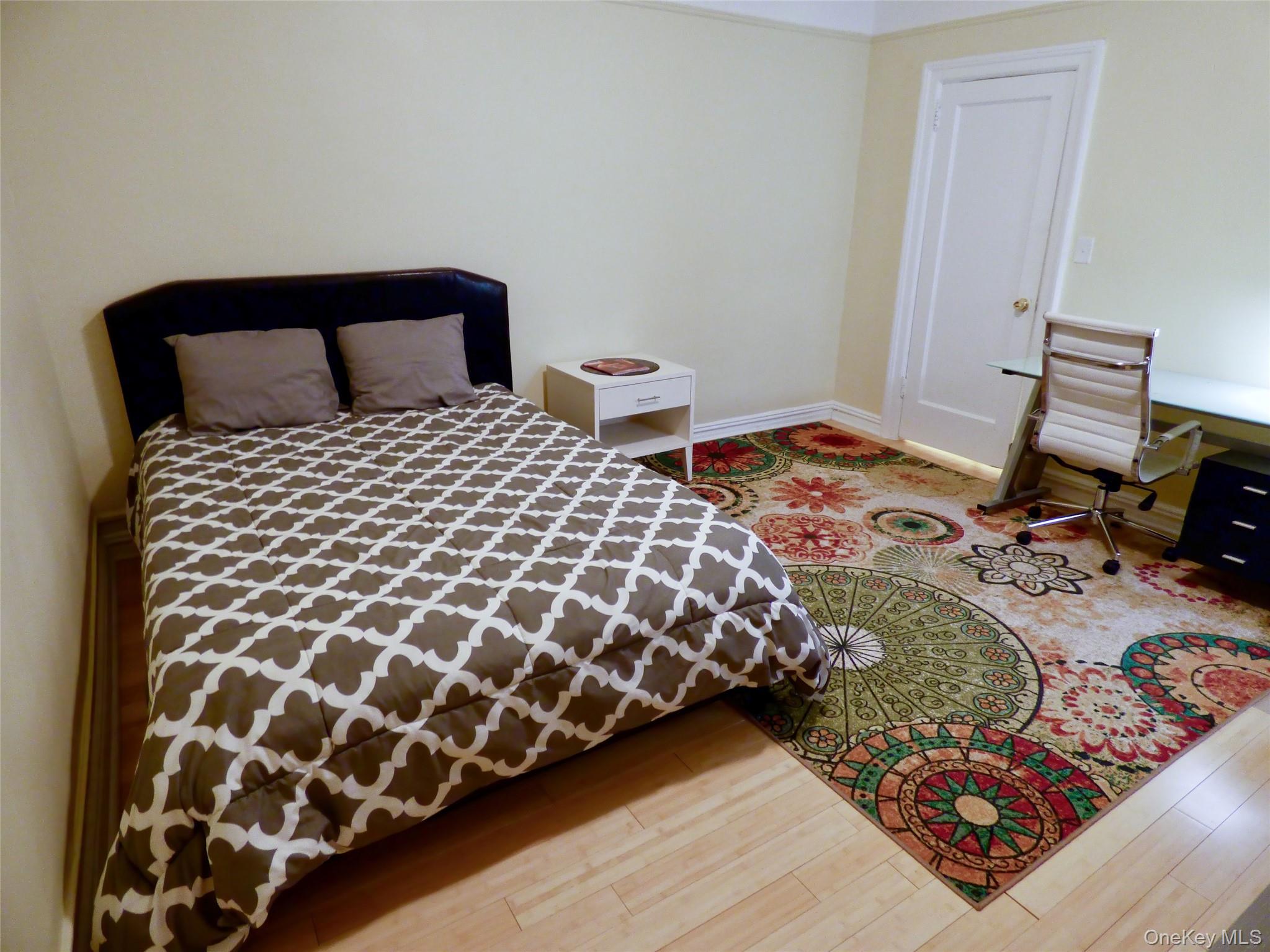 941 Jerome Avenue, Unit D5 Bronx, NY 10452 - Photo 4 of 35 a bedroom with a bed and wooden floor