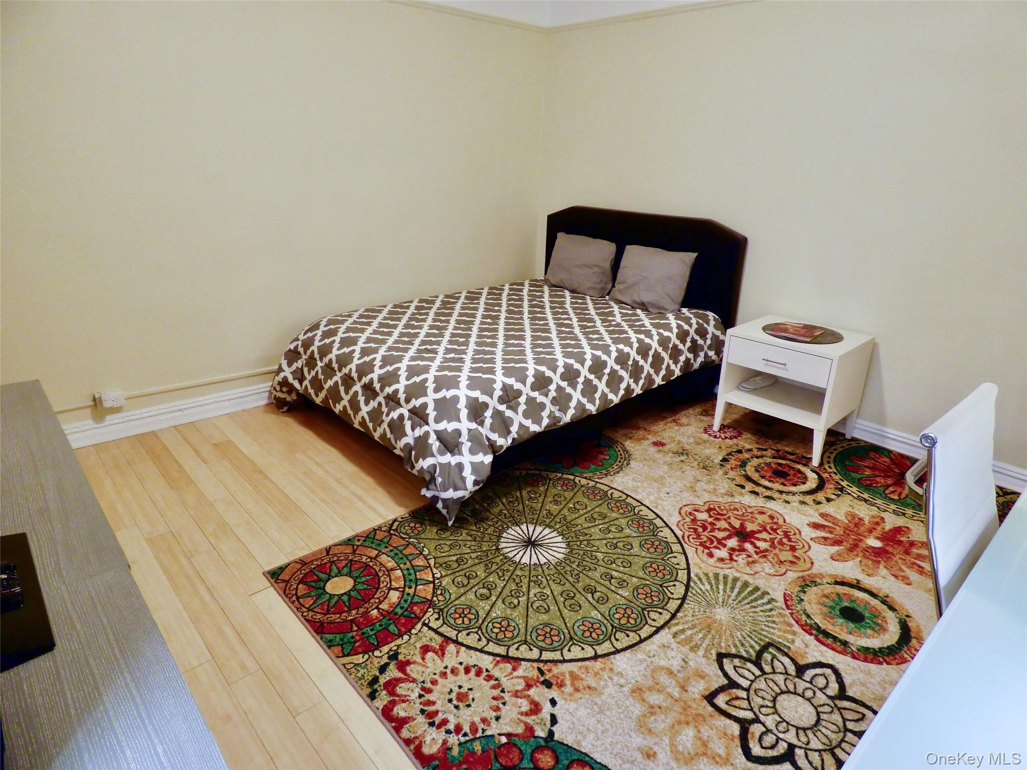 941 Jerome Avenue, Unit D5 Bronx, NY 10452 - Photo 6 of 35 a bedroom with a bed and a wooden floor