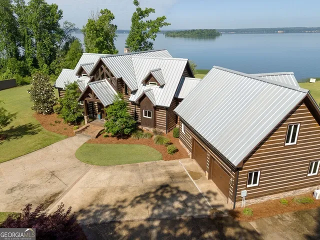 an aerial view of a house with a yard and lake view