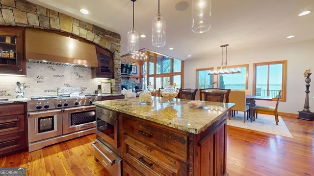 a kitchen with stainless steel appliances granite countertop a stove and a view of living room