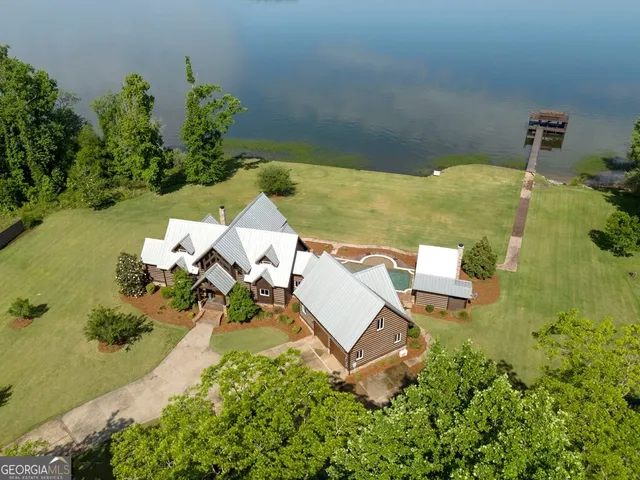 an aerial view of a house with a yard and lake view