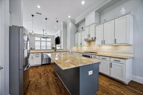 a kitchen with stainless steel appliances granite countertop a sink stove and refrigerator