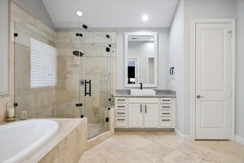 a spacious bathroom with a sink a mirror a bathtub and shower