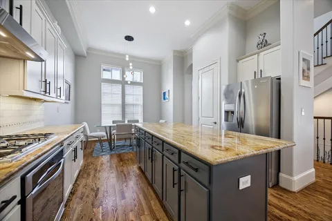 a kitchen with granite countertop a sink stove and refrigerator