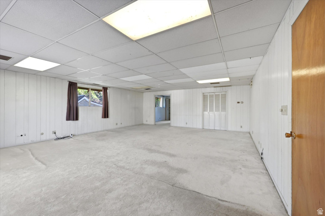 292 West 400 South Springville, UT 84663 - Photo 20 of 37 Spacious room featuring light-colored carpet, white vertical paneling, and a drop ceiling with integrated lighting