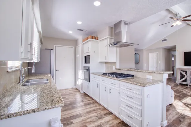 a kitchen with stainless steel appliances granite countertop a sink stove and refrigerator