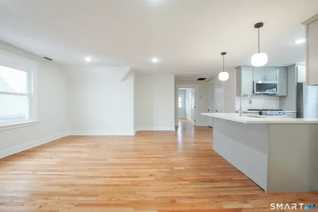a view of large kitchen with granite countertop stove top oven and cabinets