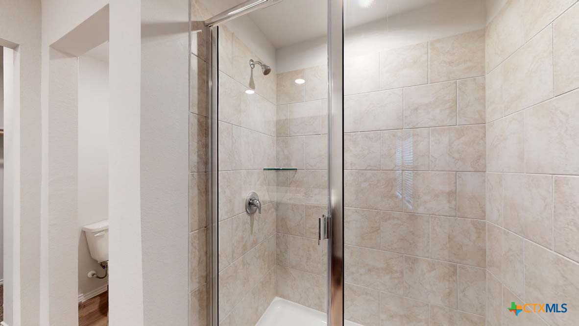 553 Hector Loop Georgetown, TX 78626 - Photo 14 of 21 a bathroom with a shower and a mirror
