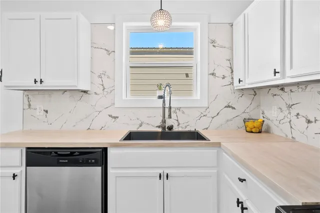 a kitchen with stainless steel appliances a sink stove and cabinets