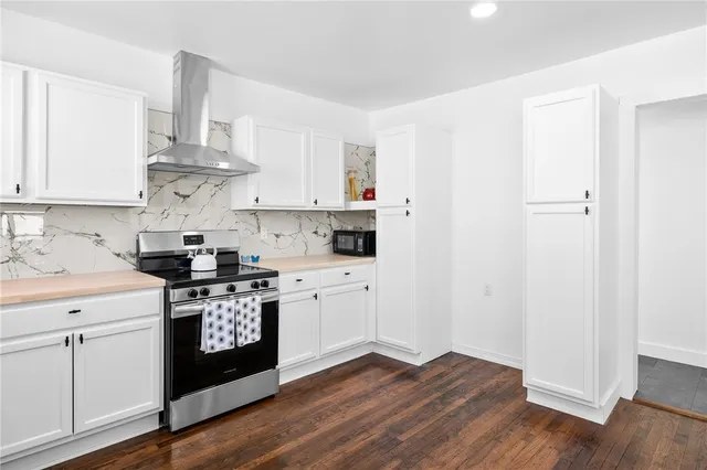 a kitchen with cabinets appliances and a wooden floor