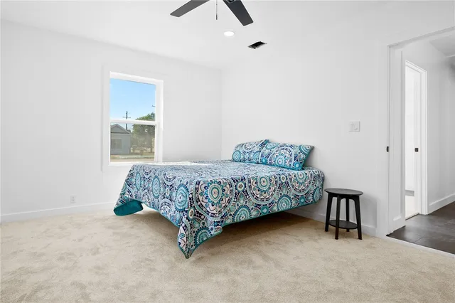 a bedroom with a bed and painting on the wall