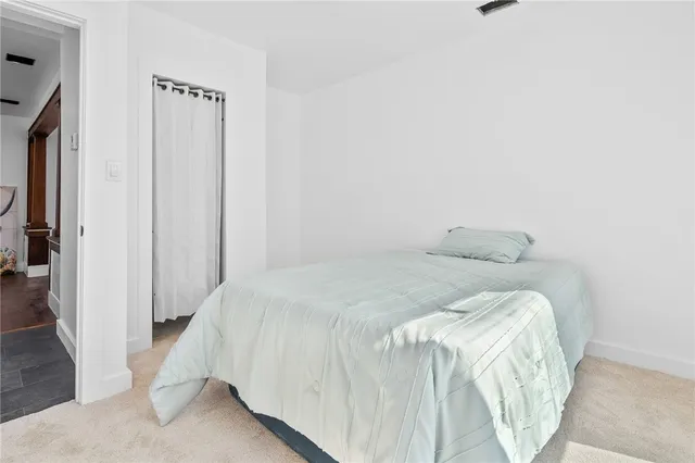 a bed sitting in a bedroom next to a window