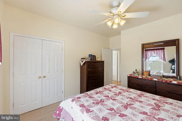 a bedroom with a bed and a dresser with mirror