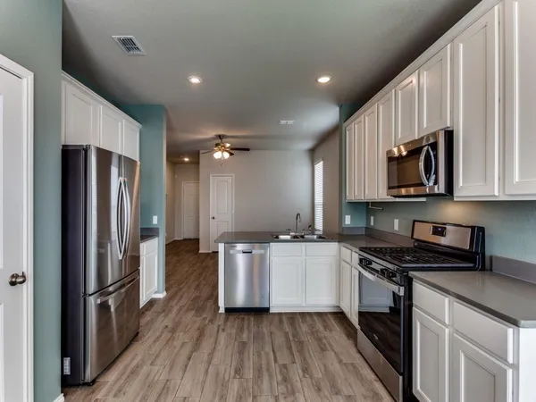 a kitchen with stainless steel appliances a refrigerator sink and microwave