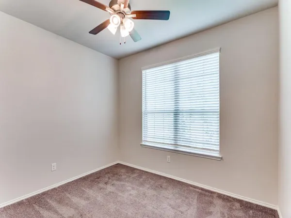 an empty room with a window and a ceiling fan
