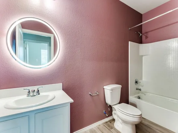 a bathroom with a toilet sink vanity and mirror