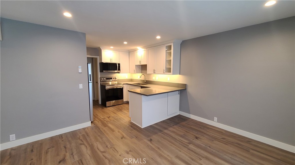 215 Lower Cliff Drive, Unit B Laguna Beach, CA 92651 - Photo 2 of 17 a kitchen with a sink cabinets and wooden floor