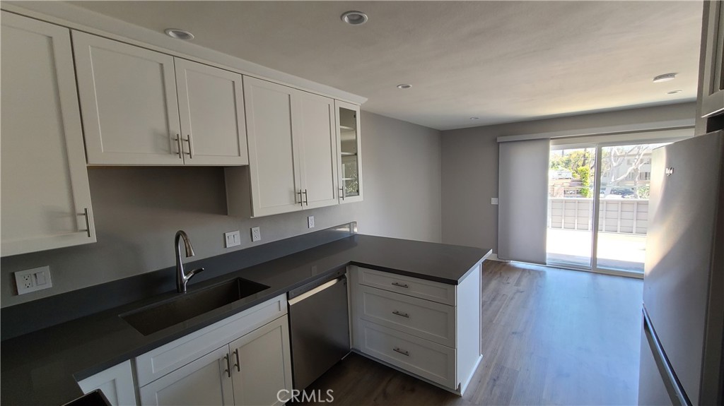215 Lower Cliff Drive, Unit B Laguna Beach, CA 92651 - Photo 3 of 17 a kitchen with granite countertop white cabinets and sink