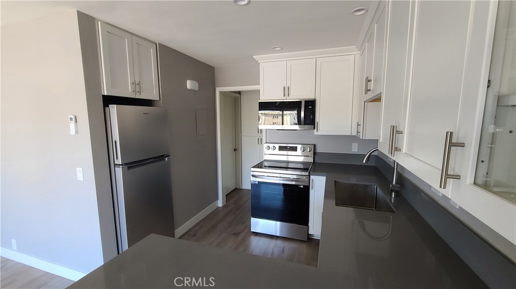 215 Lower Cliff Drive, Unit B Laguna Beach, CA 92651 - Photo 5 of 17 a kitchen with stainless steel appliances a refrigerator and a stove top oven