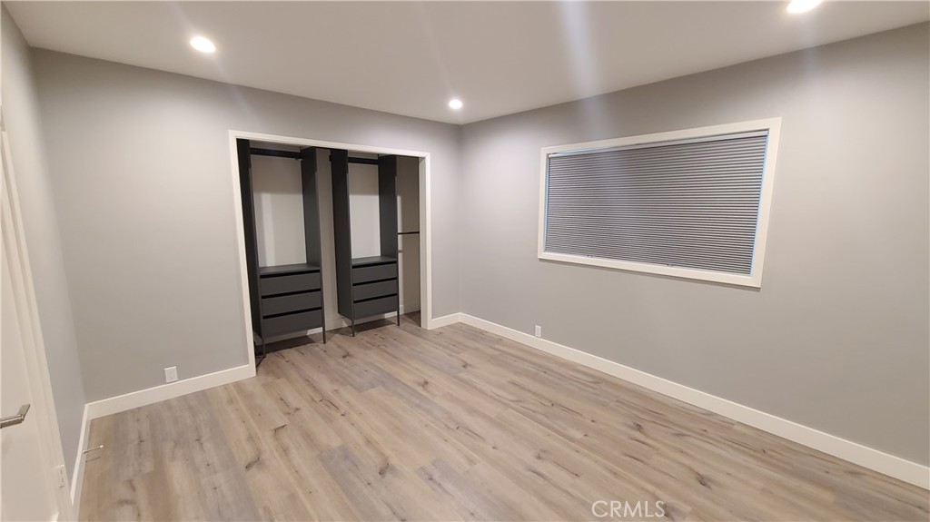 215 Lower Cliff Drive, Unit B Laguna Beach, CA 92651 - Photo 7 of 17 an empty room with wooden floor and closet