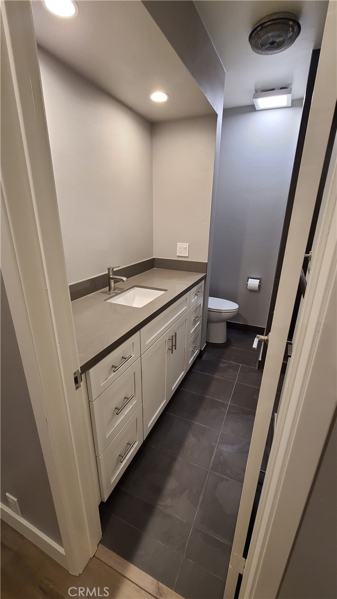 215 Lower Cliff Drive, Unit B Laguna Beach, CA 92651 - Photo 8 of 17 a bathroom with a granite countertop sink a toilet and a mirror