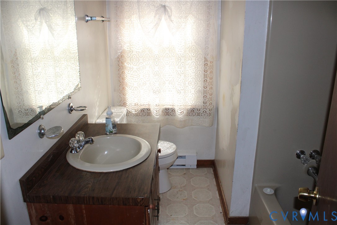 7421 Adkins Road Charles City, VA 23030 - Photo 5 of 14 a bathroom with a sink a toilet and a mirror