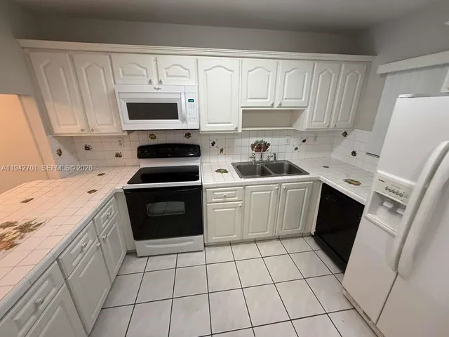 a kitchen with a stove sink and cabinets