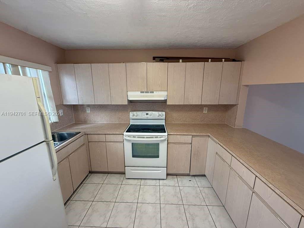 305 West 68th Street, Unit 519 Hialeah, FL 33014 - Photo 11 of 11 a kitchen with a stove sink and cabinets