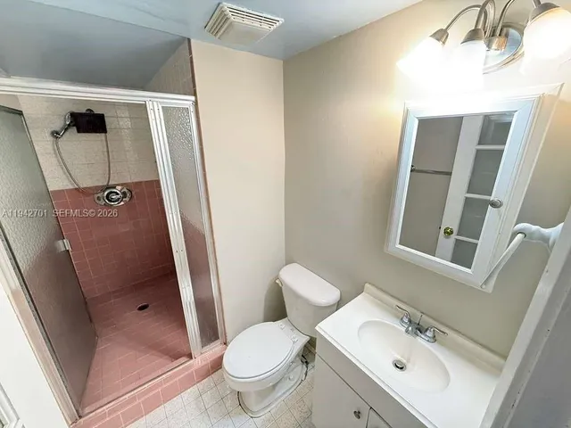 a bathroom with a sink and mirror with toilet