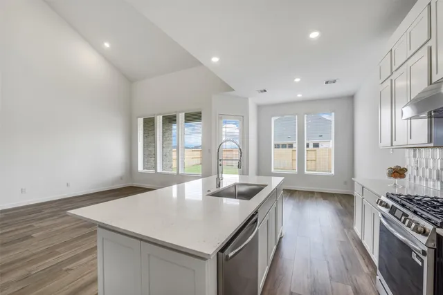 a kitchen with a stove a sink and a refrigerator