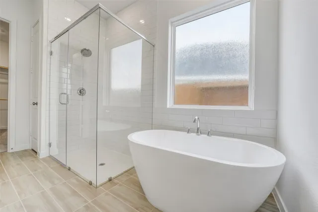 a white bath tub sitting next to a shower