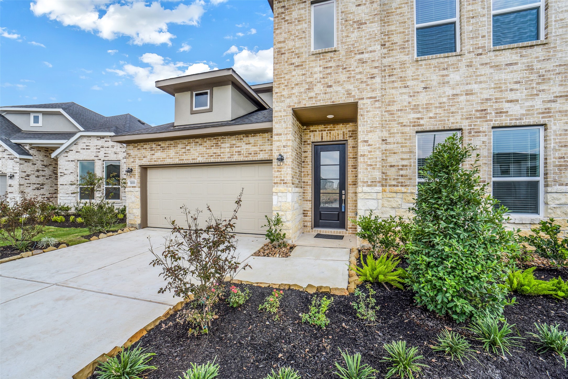 31111 Marlow Mnr Court Fulshear, TX 77441 - Photo 2 of 34 a front view of a house with garden