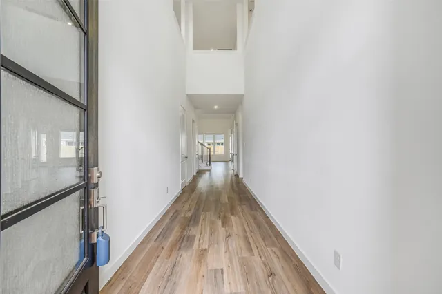 a view of a hallway with wooden floor and staircase