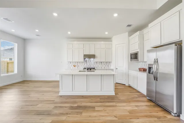 a large kitchen with kitchen island a sink stainless steel appliances and cabinets