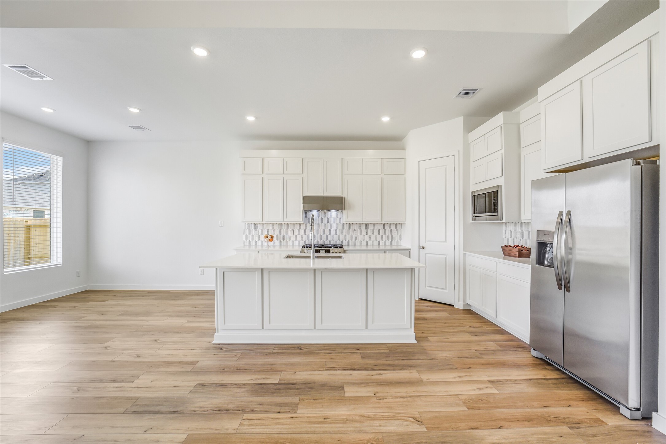 31111 Marlow Mnr Court Fulshear, TX 77441 - Photo 6 of 34 a large kitchen with kitchen island a sink stainless steel appliances and cabinets